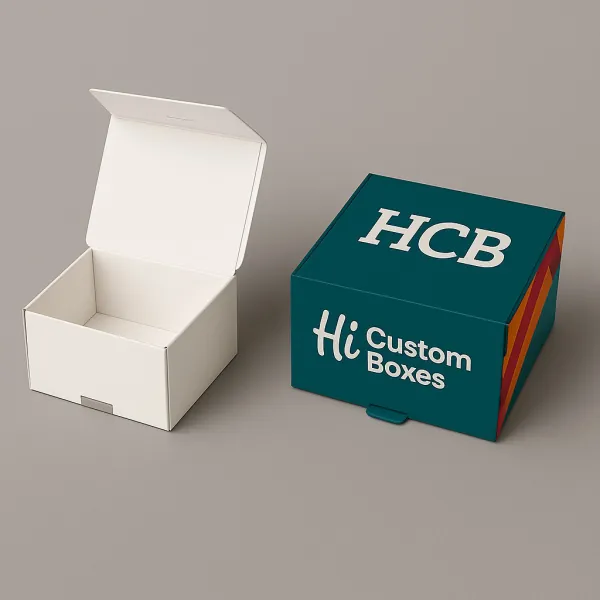 Open plain white box beside closed HCB display box with colourful striped side design class=