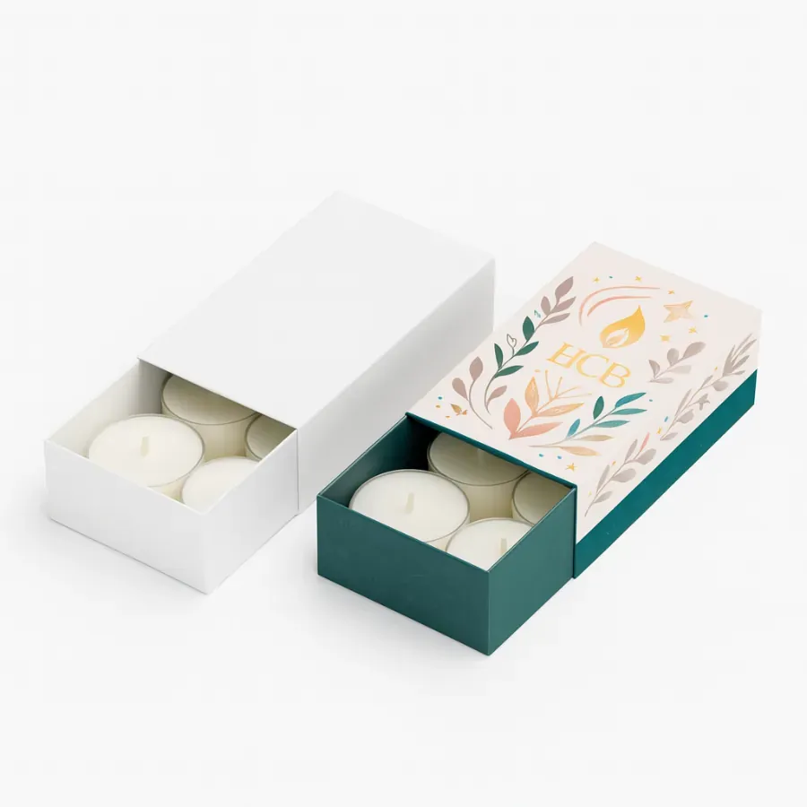 Drawer-style candle packaging boxes containing tealight candles- one plain white and the other with HCB branding in teal and pink floral design class=