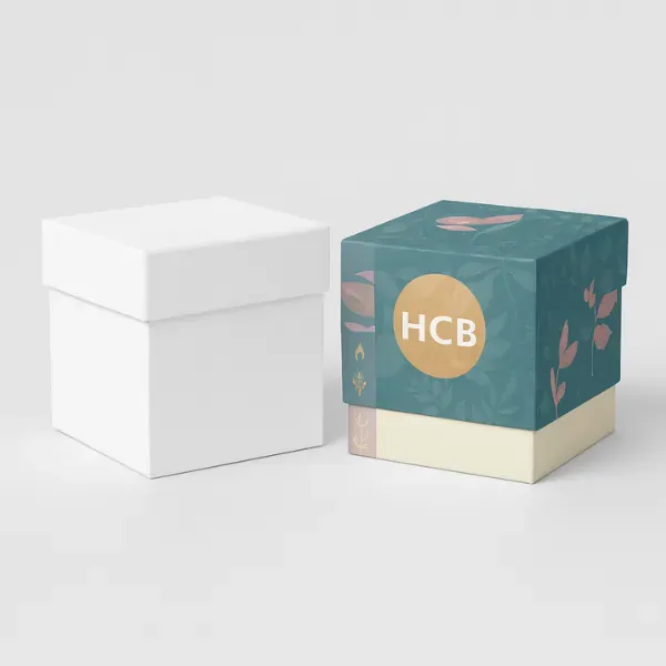 Plain white cube box next to a printed teal and cream cube box with floral patterns and -HCB- logo