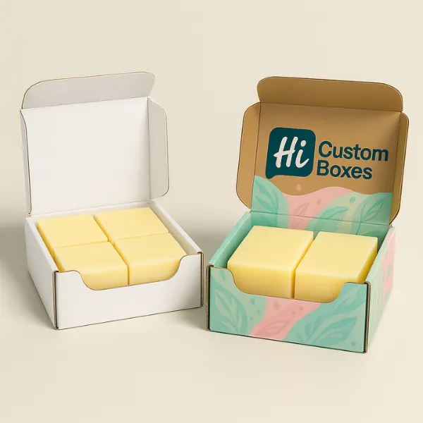 Two mailer-style soap boxes- one plain white and one custom printed with pastel leaf patterns- each holding four yellow soap bars inside- class=