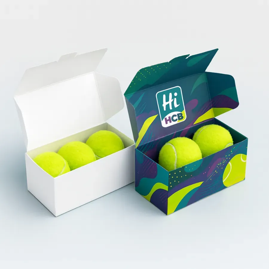 Custom printed Hi HCB packaging box with colorful abstract graphics holding three neon yellow tennis balls- shown beside a plain white box class=