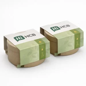 Two round cardboard tubs wrapped in eco-friendly green sleeves featuring botanical illustrations and laboratory icons