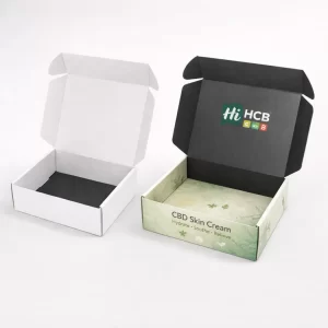 Two open cardboard mailing boxes showing a black interior lid and a branded botanical product base.