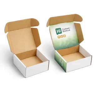 Two open cardboard mailing boxes, one plain white and one with a green branded lid.