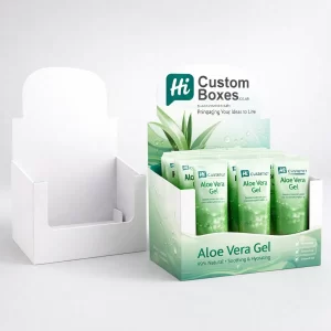 A white cardboard counter display unit next to a branded green version filled with gel tubes.