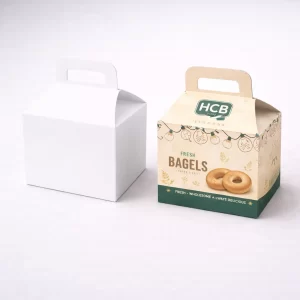Two cardboard gable boxes with handles, showing a plain white version and a decorated bagel box.