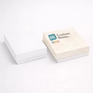 Two shallow square lidded gift boxes, one plain white and one with an elegant cream damask print.