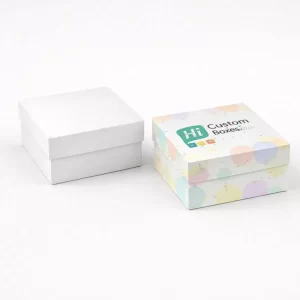 Two square rigid gift boxes, one plain white and one decorated with colourful pastel dots.