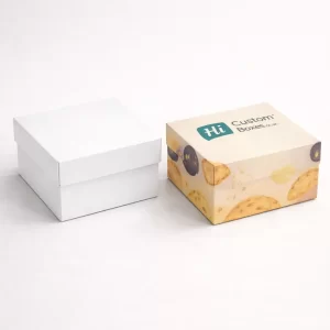 Two simple square biscuit boxes with lids, one plain white and one with a branded pattern.