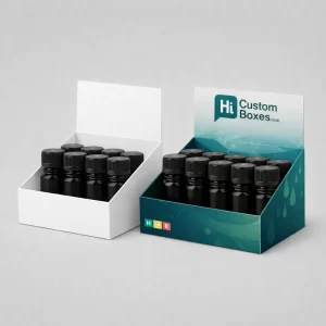 Two counter-top display boxes holding small black bottles- one plain white and one with teal branding