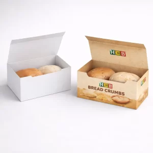 Two open rectangular boxes containing fresh bread rolls, one plain white and one with decorative wheat illustrations.