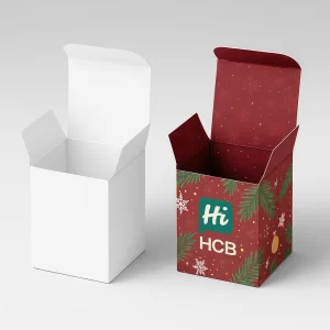 Two open square cardboard candle boxes, one plain white, one deep red Christmas design.