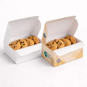 Two open biscuit boxes with hinged lids, each containing a row of chocolate chip biscuits.