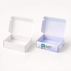 An open plain white mailer box beside a lilac box featuring a crescent moon design.