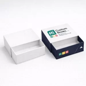Two open mailing boxes containing folded shirts, showcasing a plain white and a branded navy design