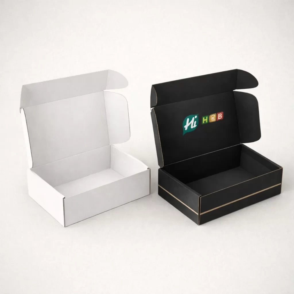 Open cardboard mailer boxes shown in white and black, featuring internal branding and thin gold lines.