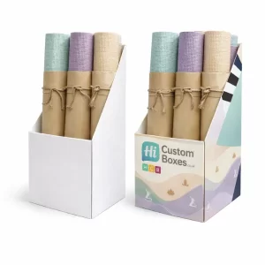 Two cardboard display stands holding rolled yoga mats wrapped in brown paper with rustic twine bows.