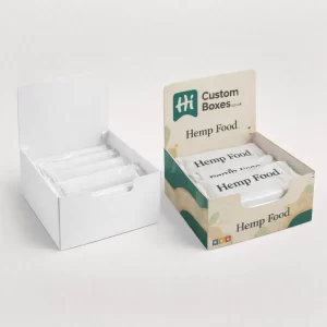 Counter display boxes containing packaged hemp bars, featuring one plain white and one with colourful botanical patterns.