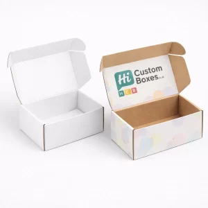 Two open cardboard mailer boxes, one white and one featuring a colourful branded internal lid.