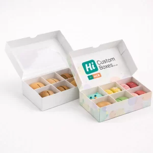 Two open white macaron boxes with dividers, one featuring a pastel-coloured polka dot design.