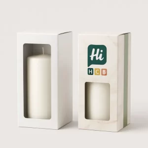 Two tall candle packaging boxes- one plain white with an open flap and the other custom printed with teal and pink candle illustrations- leaf motifs- and -Hi- branding- Both boxes feature a clear front window to display the product inside