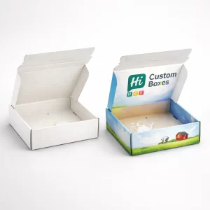 Two large corrugated cardboard boxes, one plain white and one with blue and green dairy branding.
