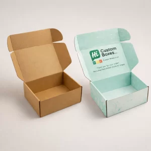 Two open cardboard mailing boxes, one natural brown kraft and one with a light blue floral lining.