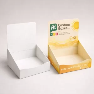 Two cardboard counter display boxes, one plain white and one branded for sun care protection.