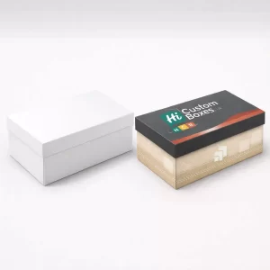 A plain white box next to a premium branded box with a dark grey lid.