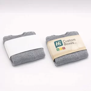 Folded grey jumpers secured with paper belly bands, featuring one plain and one branded design.