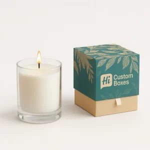 Burning candle in a glass jar next to a bespoke teal and tan two-piece pull-out box.