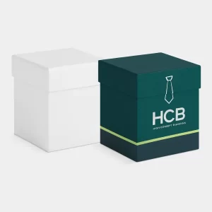 Square custom-printed lift-off lid tie boxes with HCB logo in dark teal and white for branded apparel