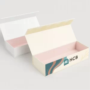 Custom rigid drawer box with ribbon pull tab- plain white on the left and branded design on the right featuring HCB logo and teal ribbon handle