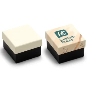 Two square rigid boxes for cosmetics packaging. One is plain cream with a black base, while the other is custom-printed with "HC Custom Boxes" logo and a soft peach design on the lid.