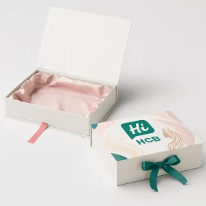 Luxury rigid flip-top box with pastel interior- plain version on the left and printed version on the right with HCB logo and decorative wave design