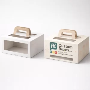 Rectangular white and branded cake boxes featuring brown handles and large windows for bakery displays. Rectangular white and branded cake boxes featuring brown handles and large windows for bakery displays.