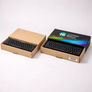 Two brown cardboard boxes with slide-out trays, each containing a black mechanical keyboard, one branded.