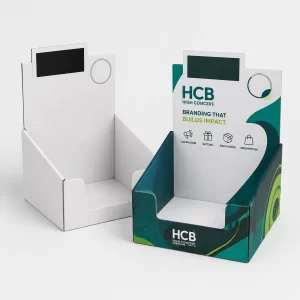 White and branded teal cardboard countertop display boxes for retail products.
