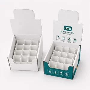 Two white counter display boxes with internal dividers and one featuring custom teal branding and logos.