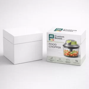 A square white gift box positioned beside a branded retail box for a green food chopper.