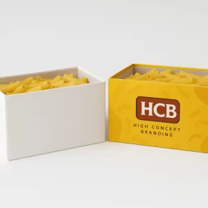 A plain white box and a yellow branded box filled with dry macaroni pasta shapes