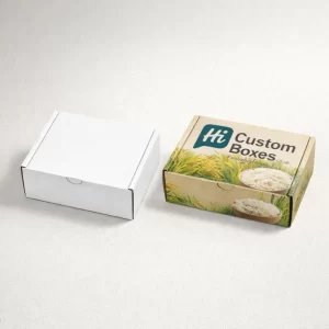 Two small rectangular cardboard mailing boxes, showing a plain white version and a custom-printed rice design.