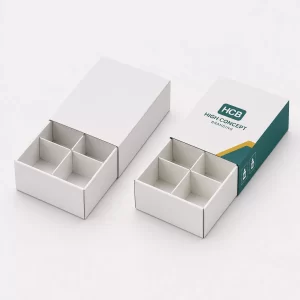 Two white sleeve boxes with internal cardboard dividers and one featuring teal
