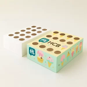 Ice cream boxes designed to hold multiple mini-cones or popsicles- featuring die-cut holes and a colorful branded pattern with ice cream illustrations- next to a plain white version
